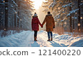 Couple holding hands on snowy forest path at sunset. 121400220