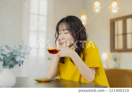 A woman in a yellow dress at a cafe 121400319