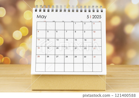May 2025 desk calendar on wooden table with gold light bokeh. May 2025 desk calendar on wooden table with gold light bokeh. 121400588