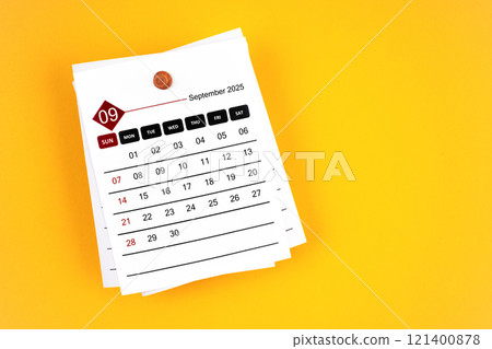 September 2025 calendar page with wooden push pin on yellow background. 121400878