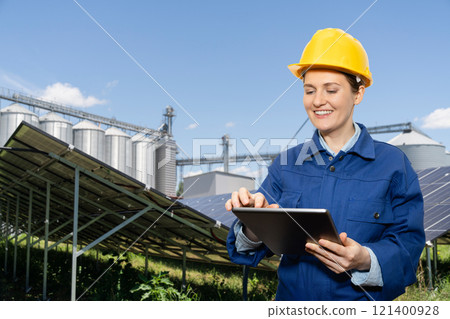 Engineer with digital tablet on a background of modern farm using renewable energy.. Engineer with digital tablet on a background of modern farm using renewable energy.. 121400928