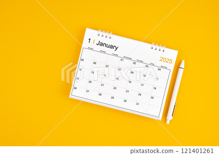 January 2025, Monthly desk calendar for 2025 year and pen on yellow background. January 2025, Monthly desk calendar for 2025 year and pen on yellow background. 121401261