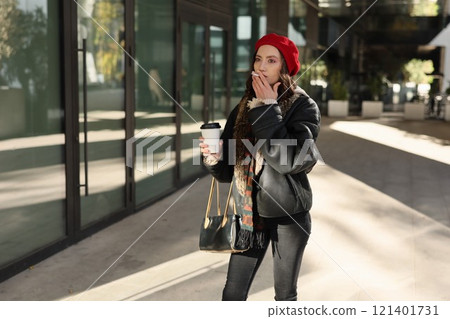 A Stylish Woman is Enjoying Her Coffee Outdoors in a Vibrant Urban Setting Today A Stylish Woman is Enjoying Her Coffee Outdoors in a Vibrant Urban Setting Today 121401731