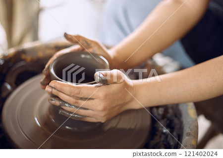 Hands of craftsman artist working on pottery wheel. Hands of craftsman artist working on pottery wheel. 121402024