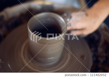 Hands of craftsman artist working on pottery wheel. 121402032