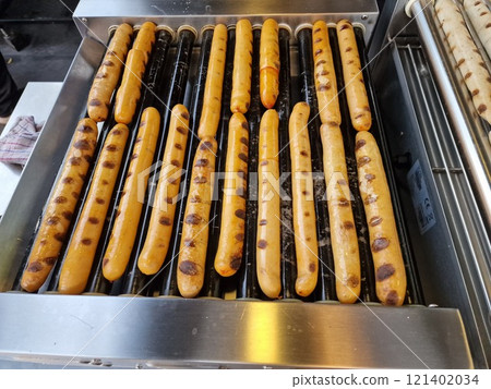Sausage cooking on rolling bars 121402034