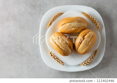 French buns and wheat ears on a marmoreal table. 121402446