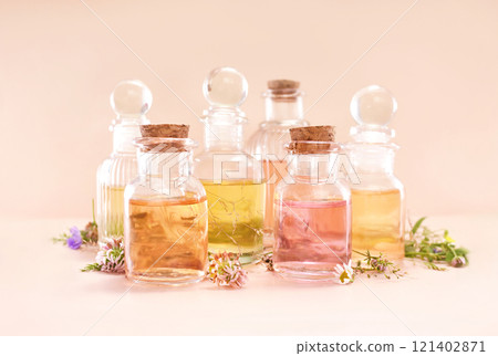 Colorful essential oil bottles and medicinal herbs background, selective focus 121402871