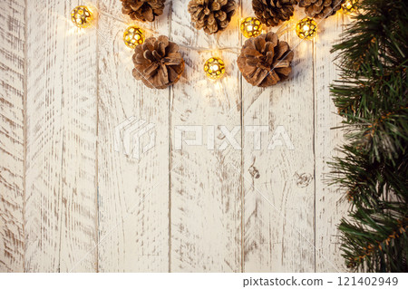 White wooden Christmas background. Empty space for text. Happy New Year. Cones, spruce branch, garland White wooden Christmas background. Empty space for text. Happy New Year. Cones, spruce branch, garland 121402949