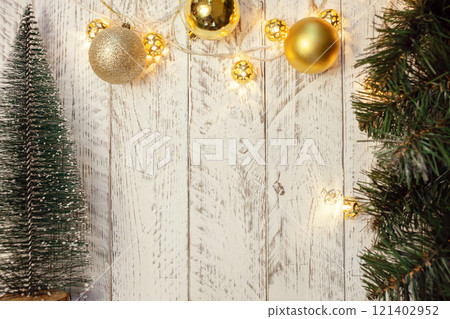 White wooden Christmas background. Empty space for text. Happy New Year. Small Christmas trees, garland with lights. 121402952