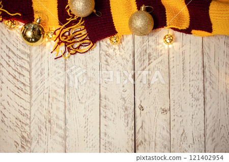 White wooden Christmas background. Empty space for text. Happy New Year. Christmas balls, garland, brown-red scarf. 121402954