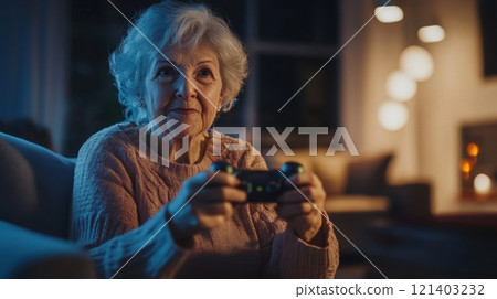 Elderly woman playing videogames at home in the evening Elderly woman playing videogames at home in the evening 121403232