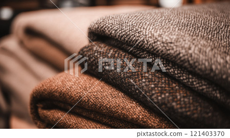 Stack of folded cozy warm winter tweed fabric showing texture 121403370