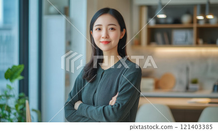 Young asian businesswoman smiling with arms crossed in modern office Young asian businesswoman smiling with arms crossed in modern office 121403385