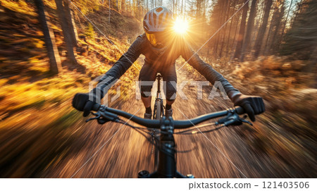 Mountain biker riding fast on trail at sunset in autumn forest Mountain biker riding fast on trail at sunset in autumn forest 121403506