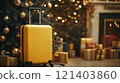 Yellow suitcase stands near decorated christmas tree symbolizing holiday travel 121403860