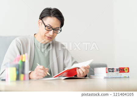 一名 30 多歲的男子正在查看有關重新技能的參考書 121404105