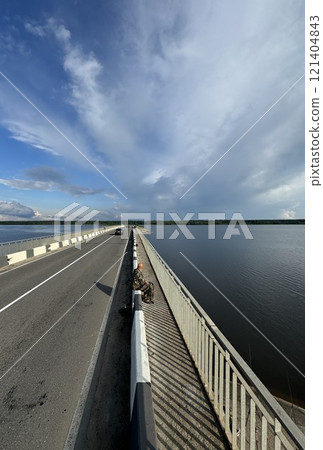 Riverside Bridge with Angler Under Blue Sky 121404843