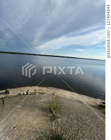 Scenic Riverside View with Fishermen on the Shore 121404844