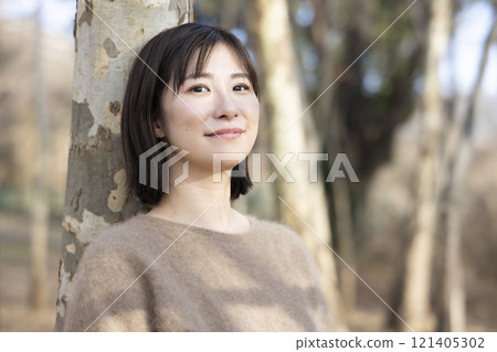 A woman walking through the forest A woman walking through the forest 121405302
