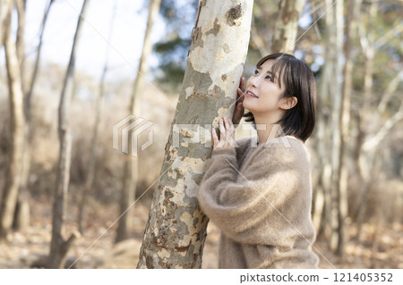 A woman walking through the forest A woman walking through the forest 121405352