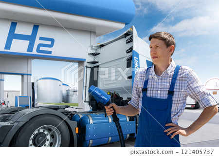 Man with H2 nozzle on a background of hydrogen fuel cell semi truck with H2 gas cylinder onboard. Eco-friendly commercial vehicle concept. Man with H2 nozzle on a background of hydrogen fuel cell semi truck with H2 gas cylinder onboard. Eco-friendly commercial vehicle concept. 121405737