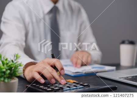 Businessman using calculator bookkeeping payroll and budget tax. Business document finance accounting investment Businessman using calculator bookkeeping payroll and budget tax. Business document finance accounting investment 121407275