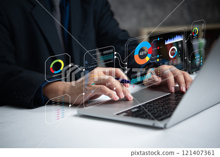 A person operates a laptop displaying digital analytics charts and graphs. A person operates a laptop displaying digital analytics charts and graphs. 121407361