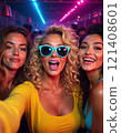 woman influencer taking a group selfie at a party, fun vibe, party lights background in the club with glitter 121408601