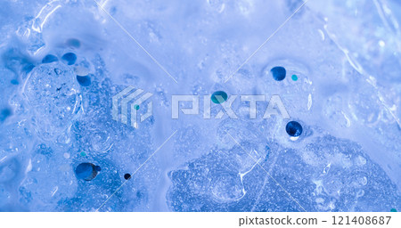 Frozen surface. Water glitter. Cold liquid with decorative sparks flows down blue ice. Light color mystery paint defocused background with neon effect. Frozen surface. Water glitter. Cold liquid with decorative sparks flows down blue ice. Light color mystery paint defocused background with neon effect. 121408687