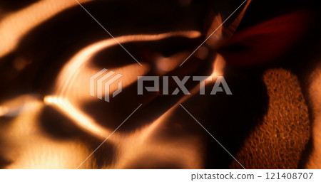 Film burn. Defocused glow. Blinking sparkling majestic lens flare golden yellow glistering shining flickers on abstract art dark background. 121408707