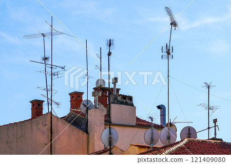 Many aerial digital television reception antennas and satellite dishes installed on the rooftop 121409080