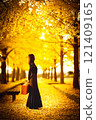 A woman taking a photo under a beautiful ginkgo tree 121409165