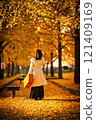 Cute woman under a ginkgo tree 121409169
