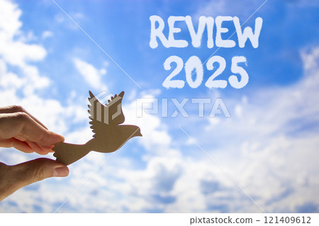 Planning review 2025 new year symbol. Concept words Review 2025 on beautiful blue sky. Beautiful blue sky clouds background. Hand with wooden bird. Business review 2025 new year concept. Copy space. Planning review 2025 new year symbol. Concept words Review 2025 on beautiful blue sky. Beautiful blue sky clouds background. Hand with wooden bird. Business review 2025 new year concept. Copy space. 121409612