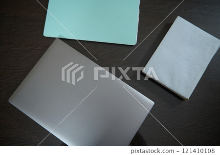 Minimalist workspace setup with laptop and notebooks on dark wooden desk Minimalist workspace setup with laptop and notebooks on dark wooden desk 121410108