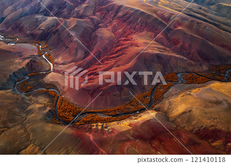 Aerial view of a vibrant red mountain valley with winding river 121410118