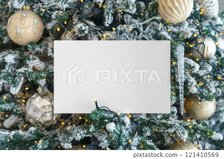 White blank paper rectangle on festive decorated Christmas tree showy branches background 121410569