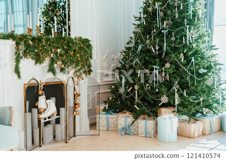 Festive Christmas tree with wrapped gift boxes and decorated fireplace in cozy living room Festive Christmas tree with wrapped gift boxes and decorated fireplace in cozy living room 121410574