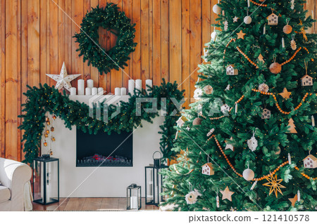 Decorated Christmas tree with wrapped presents in cozy wooden interior during holiday season 121410578