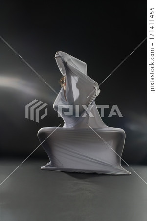 Sculpture emerging from translucent material in a minimalistic setting 121411455
