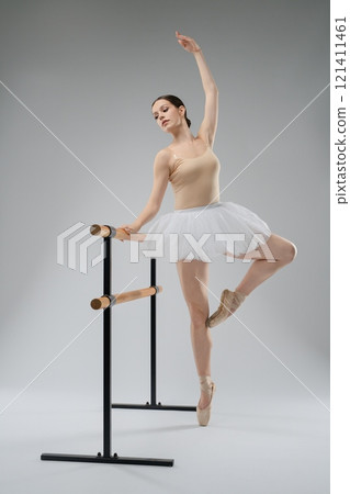 Ballet dancer practicing at the barre in a studio setting 121411461