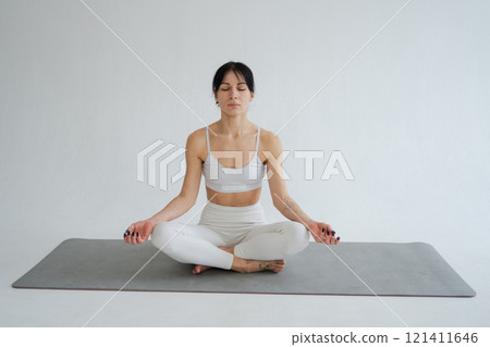 Yoga mindfulness meditation. Healthy woman practicing yoga isolated on white background. Woman sitting in lotus pose meditating relaxing. Girl doing breathing practice. Yoga on white background 121411646