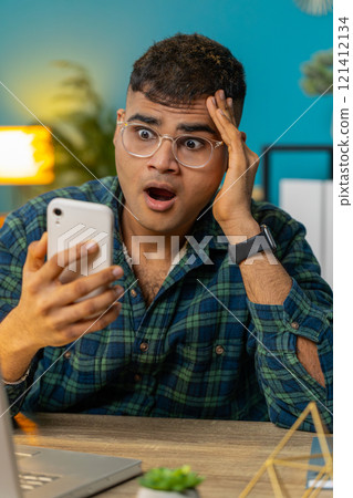 Sad Indian man use smartphone surprised by bad news fortune loss fail lottery online game results 121412134