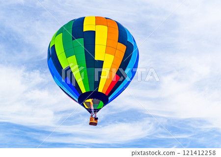 Colorful hot air balloon flying over blue sky with white clouds Colorful hot air balloon flying over blue sky with white clouds 121412258