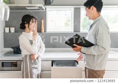 一位女家庭主婦從廚房的水管工和設備店收到有關洗碗機和洗碗機的說明。 一位女家庭主婦從廚房的水管工和設備店收到有關洗碗機和洗碗機的說明。 121413693