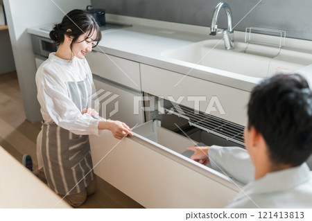 一位家庭主婦正在聽建築公司、設備商店和穿著工作服的水管工的男人說話（諮詢、合約、會議） 121413813