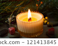 a beautiful scented candle in a transparent holder burns on a dark background. High quality photo 121413845