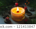 a beautiful scented candle in a transparent holder burns on a dark background. High quality photo 121413847
