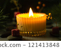 a beautiful scented candle in a transparent holder burns on a dark background. High quality photo 121413848